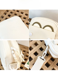 Detail view of cream canvas crossbody bag with waterproof coating and green ring accents