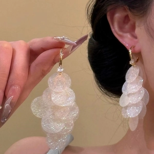 Detail of iridescent sequin tassel earrings with gold-toned metal and crystal accents