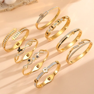 Collection de joncs en acier inoxydable plaqué or 18 carats avec divers breloques