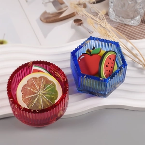 Detail van ronde en zeshoekige harscontainers met goudfolie en fruitige bedeltjes
