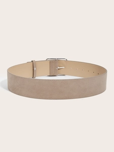 Detail of wide taupe suede leather belt with silver metal buckle and adjustable holes