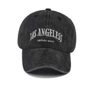 Close-up of white Los Angeles lettering embroidery on vintage washed black cotton baseball cap