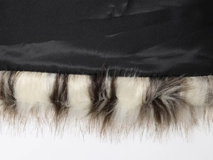 Dettaglio di fodera in raso nero e finta pelliccia bianco-marrone su cappotto moda