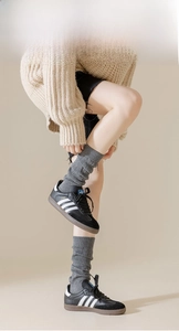 Détail de chaussettes côtelées gris foncé portées avec des baskets en cuir noir style décontracté