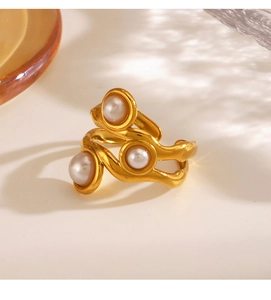 Close-up of golden irregular ring featuring three white pearls in a vintage French style