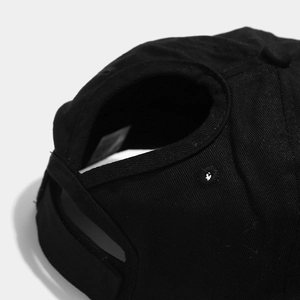 Dettaglio del foro per la coda di cavallo sul cappello da baseball nero in cotone