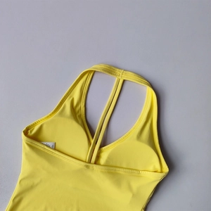 Détail du soutien-gorge de yoga jaune avec coutures précises et coussinets de poitrine