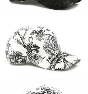 Detail of floral print baseball caps in black damask and white floral patterns
