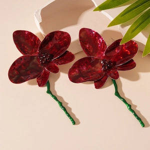 Vintage red flower earrings with sparkling crystals and golden stems on stone