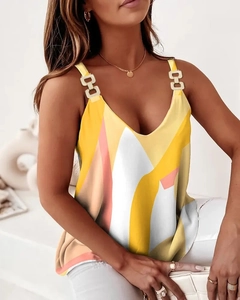 Detail of V-neck sleeveless top featuring golden metal rings and geometric prints