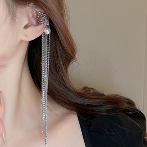 Close-up of silver tassel ear cuff with pearl detail and irregular cutout design