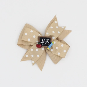 Detail of khaki polka dot bow hair clip with ABC blackboard and apple school ornaments