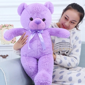 Close-up of a large purple teddy bear being held by a model to show the scale and texture