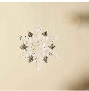 Close-up of a sparkling acrylic snowflake ornament with silver glitter for Christmas trees