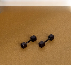 Vue macro de boucles d'oreilles minimalistes cubes noirs mats à vis en acier