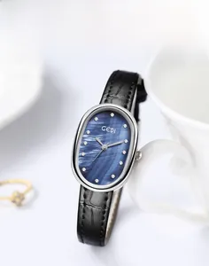 Macro shot of oval silver watch with blue mother of pearl dial and crystal markers