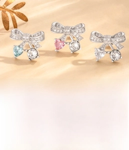 Detail of silver bow earrings with colorful heart zircons and 0.8x6mm titanium steel posts