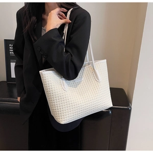 Detail of white woven tote bag featuring long slim straps and large capacity for commuting