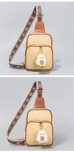Detail der Stroh-Umhängetasche mit Avocado-Plüschanhänger und Ethno-Schultergurt