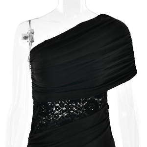 Close-up of black one-shoulder dress featuring ruched fabric and lace patchwork details