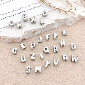 Minimalist silver DIY alphabet charms in various letters for creative jewelry making