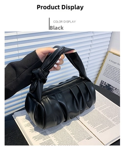 Detail shot of a black pleated cloud bag featuring a unique knotted handle and zipper closure