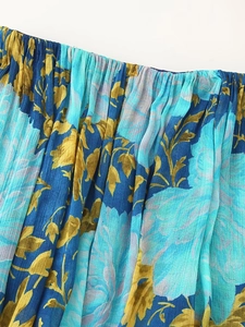 Macro detail of pleated floral chiffon fabric with blue and golden botanical patterns