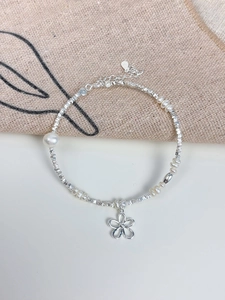 Detailed macro of S925 silver flower charm bracelet with freshwater pearls and square beads