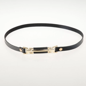 Detail of a thin black leather belt featuring a sleek gold and black metal buckle design