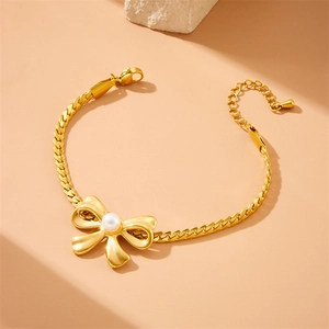 Gold-plated stainless steel woven chain bracelet with pearl bow charm and lobster clasp