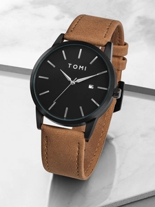 Minimalist black dial watch with brown leather strap and date display on marble stage