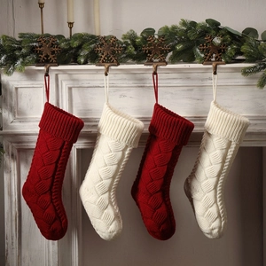 Set of 4 large cable knit Christmas stockings in red and white hanging on a white mantel