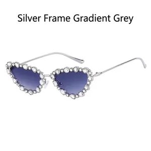 Close-up of cat-eye silver metal frames with sparkling rhinestones and gradient lenses
