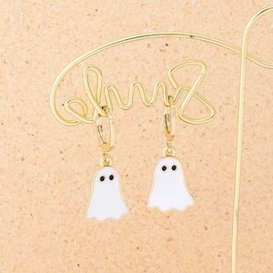 Close-up of white ghost enamel earrings hanging on a gold metal jewelry display stand