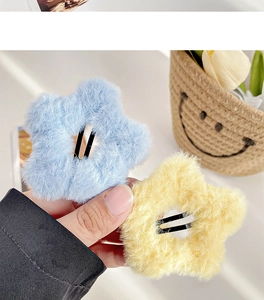 Detailed macro view of soft sky blue and pale yellow plush star hair clips for autumn