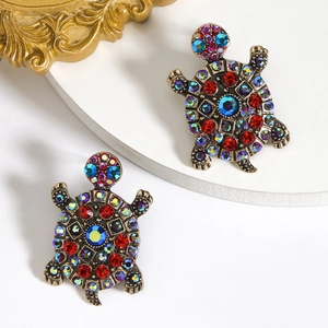Detailed close-up of crystal turtle earring with colorful rhinestones on a gold base