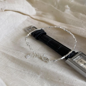 Detailed macro view of S925 sterling silver bracelet with textured silver beads and heart tag