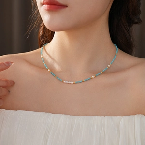 Detail of beaded necklace with turquoise beads and five natural freshwater pearls