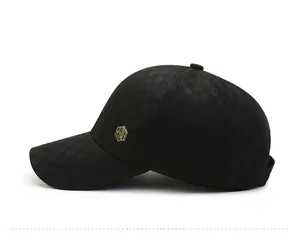 Detail of black plaid baseball cap featuring a golden RZG metal logo and textured fabric