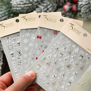 3D embossed Christmas nail art stickers featuring snowflakes and bows in festive packaging