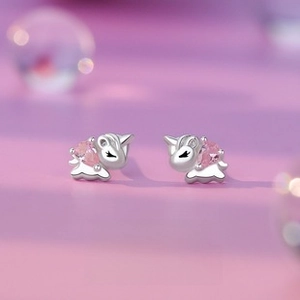 Close-up of unicorn silver earrings with pink heart zircon and detailed eyelashes