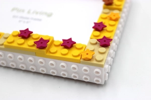 Detail shot of a DIY building block photo frame with star decorations and yellow border