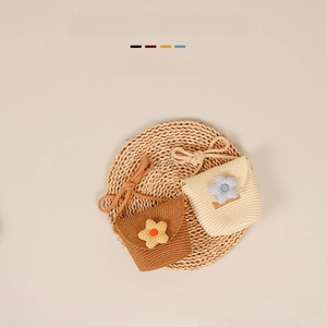 Detail of handmade straw woven mini bags with plaid fabric flowers in brown and cream