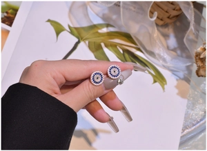 Macro view of sterling silver Evil Eye stud earrings with blue and white zircon pavé