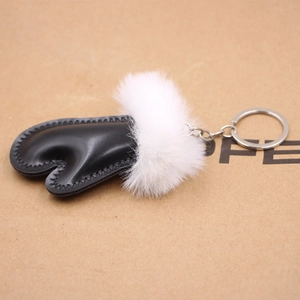 Detail of heart faux leather keychain with white plush fur ball and silver metal ring