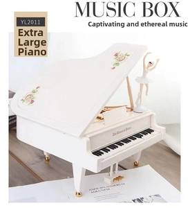 Close-up of white classical piano music box with rotating ballet dancer and floral decor