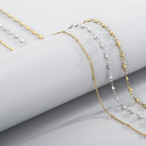 Détail de chaînes à perles minimalistes dorées et argentées au fini poli miroir