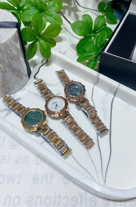 Detailed view of three small flower-shaped women's quartz watches on a marble tray