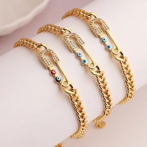 Detalle de pulseras de cadena cubana dorada con imperdible y dijes de Ojo Turco de colores