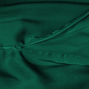 Detailed close-up of invisible zipper and dark green satin fabric on a dress